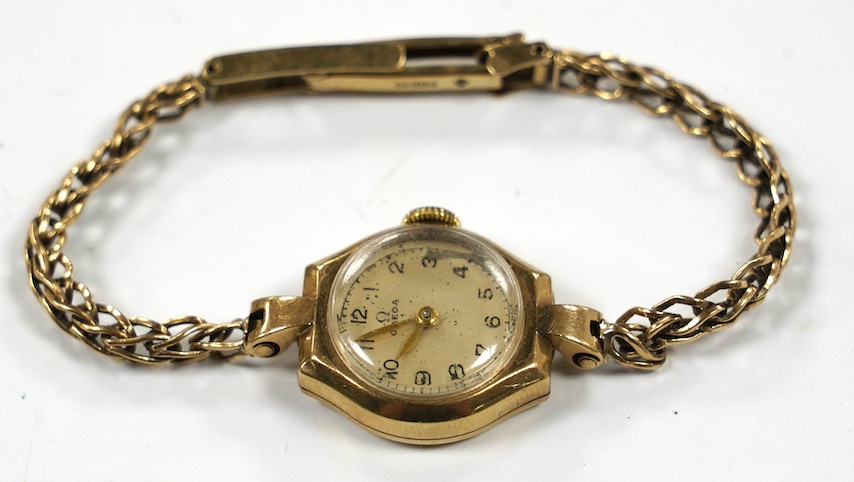 A lady's 9ct gold Omega manual wind wrist watch, on an associated 9ct bracelet, gross weight 12.8 grams. Condition - poor to fair